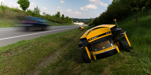 Spider mowers alongside road highway